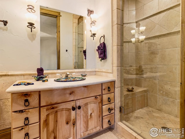 bathroom with vanity, tile walls, and a shower with shower door