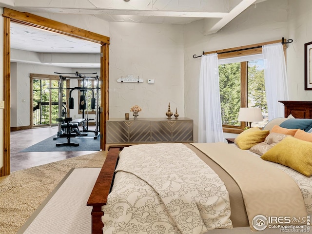 bedroom with concrete flooring, beamed ceiling, and multiple windows