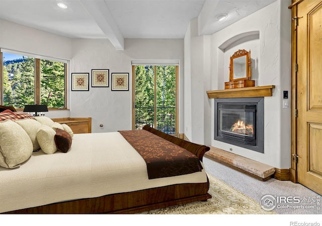 carpeted bedroom with beam ceiling and multiple windows