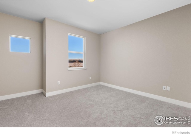 spare room featuring light colored carpet