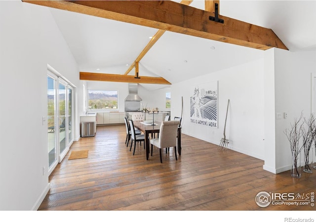 dining room featuring dark hardwood / wood-style floors and vaulted ceiling with beams