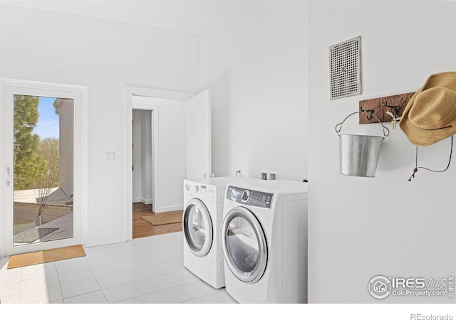 washroom featuring light tile patterned floors and washer and dryer