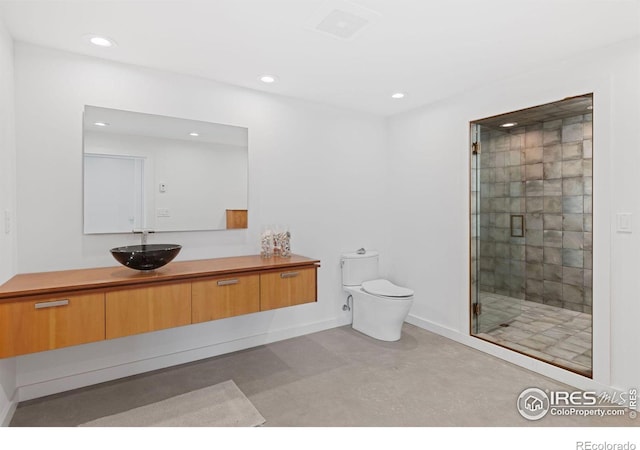 bathroom featuring vanity, a shower with door, and toilet