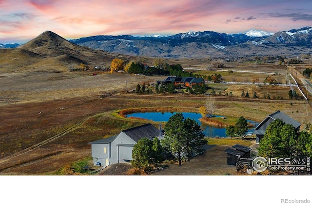 aerial view at dusk with a rural view and a water and mountain view