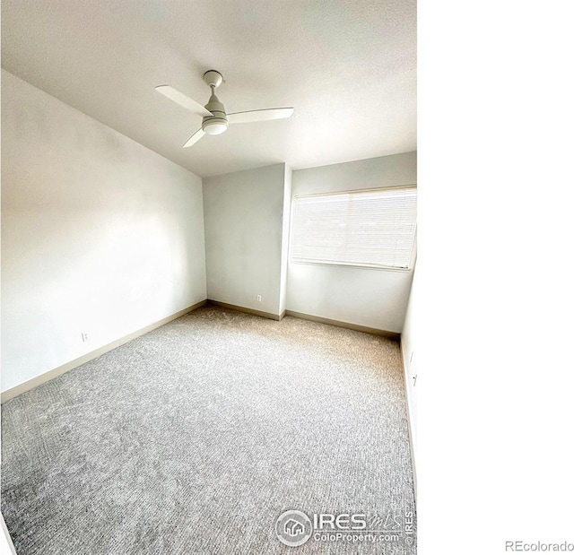 carpeted empty room with a textured ceiling, a ceiling fan, and baseboards