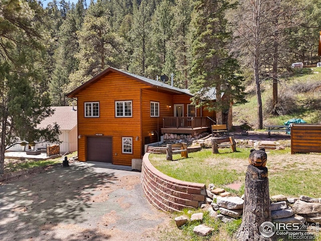 view of property exterior featuring a garage and a wooden deck