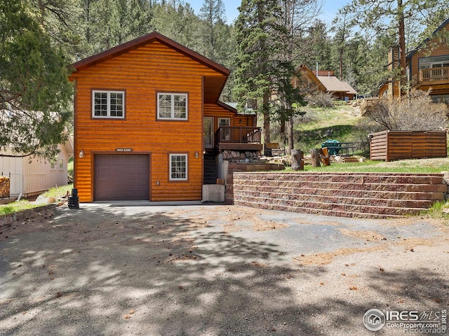 front facade with a garage and a deck