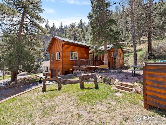 exterior space with a patio, a garage, and a deck