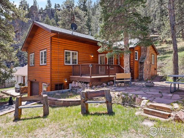 back of house with a garage, a patio, and a wooden deck