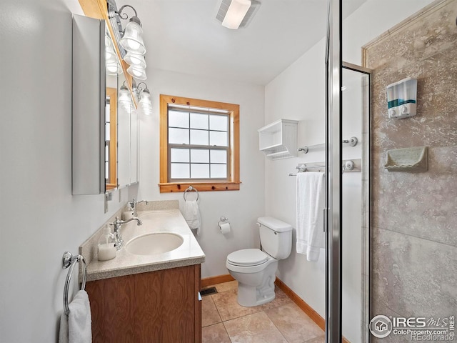 bathroom with tile patterned flooring, vanity, a shower with shower door, and toilet