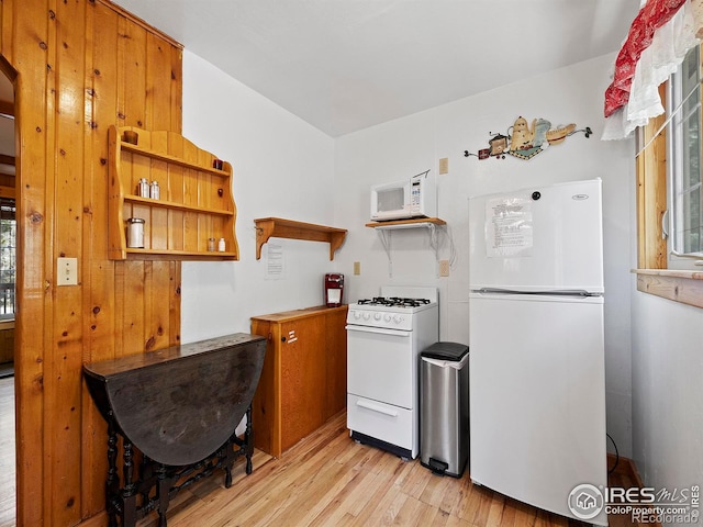 kitchen with light wood-type flooring, white appliances, and a healthy amount of sunlight