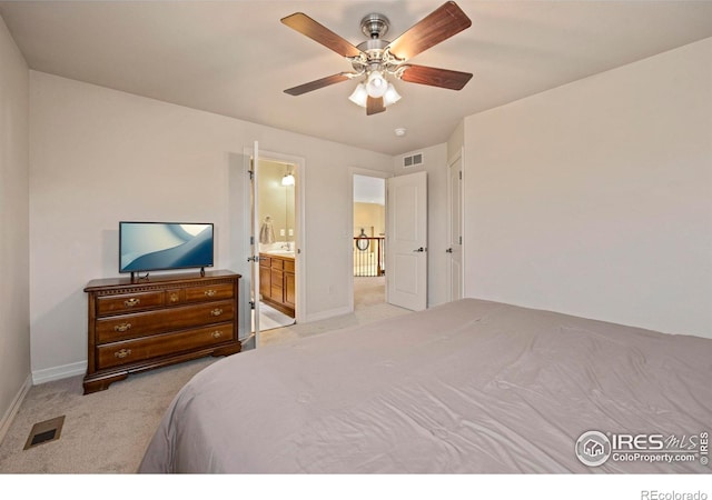 bedroom with ceiling fan, connected bathroom, and light carpet