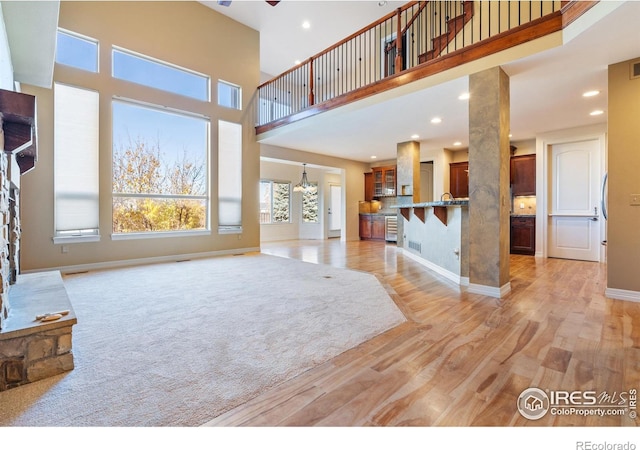 living room featuring a high ceiling and light wood-type flooring