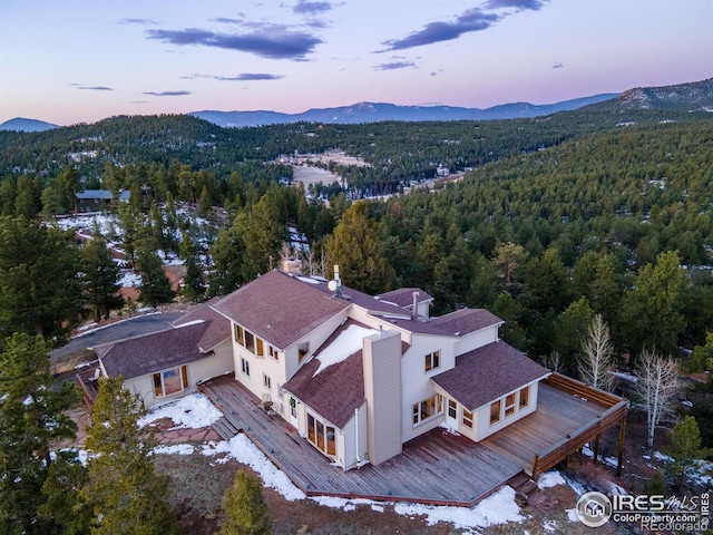 aerial view at dusk with a view of trees and a mountain view