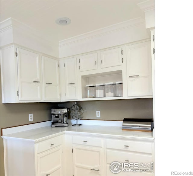 kitchen featuring ornamental molding and white cabinetry