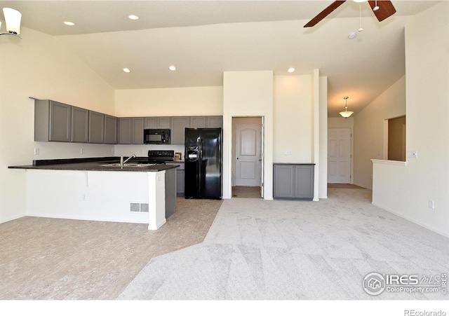 kitchen featuring ceiling fan, sink, black appliances, decorative light fixtures, and high vaulted ceiling