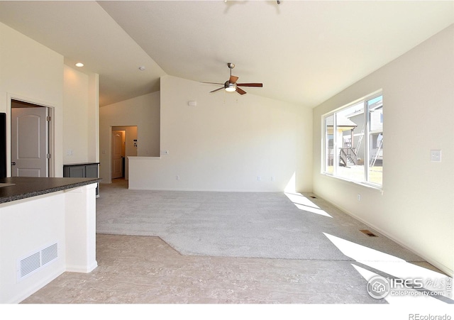 unfurnished living room with ceiling fan, light colored carpet, and lofted ceiling