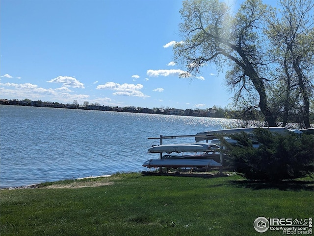 view of dock with a water view and a yard