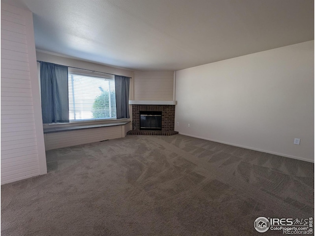 unfurnished living room featuring a brick fireplace and carpet flooring