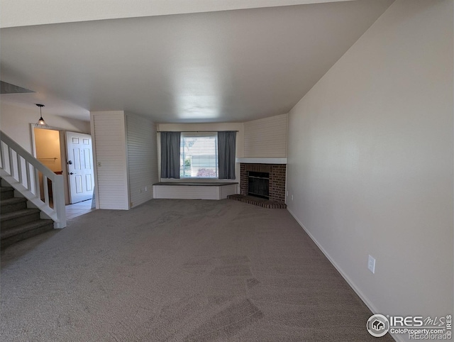 unfurnished living room with a brick fireplace and carpet floors