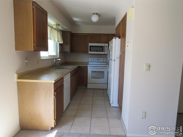 kitchen with light tile flooring, white appliances, and sink