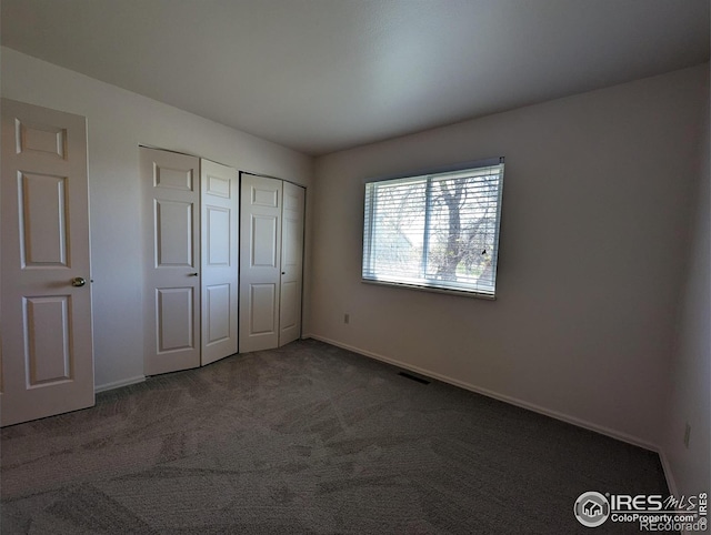 unfurnished bedroom featuring a closet and carpet floors