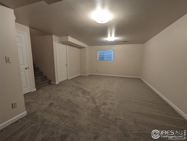 basement featuring a textured ceiling and carpet floors