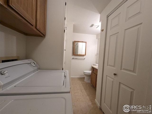 clothes washing area featuring cabinets, light tile flooring, and washer hookup