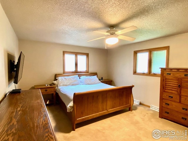 bedroom with ceiling fan, light carpet, and multiple windows