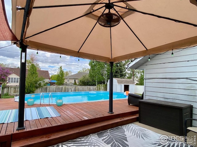 view of pool with a deck and a storage shed