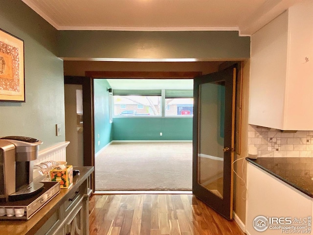 hall with light hardwood / wood-style flooring and ornamental molding