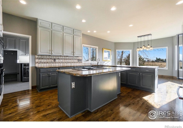 kitchen featuring gray cabinetry, a center island, and dark hardwood / wood-style floors