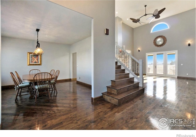 dining area featuring ceiling fan, dark hardwood / wood-style flooring, and a high ceiling