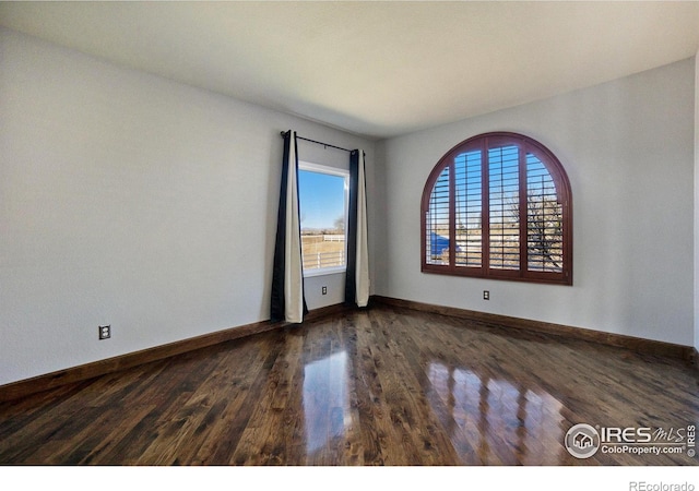 spare room with dark wood-type flooring