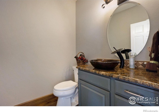 bathroom with hardwood / wood-style flooring, vanity, and toilet