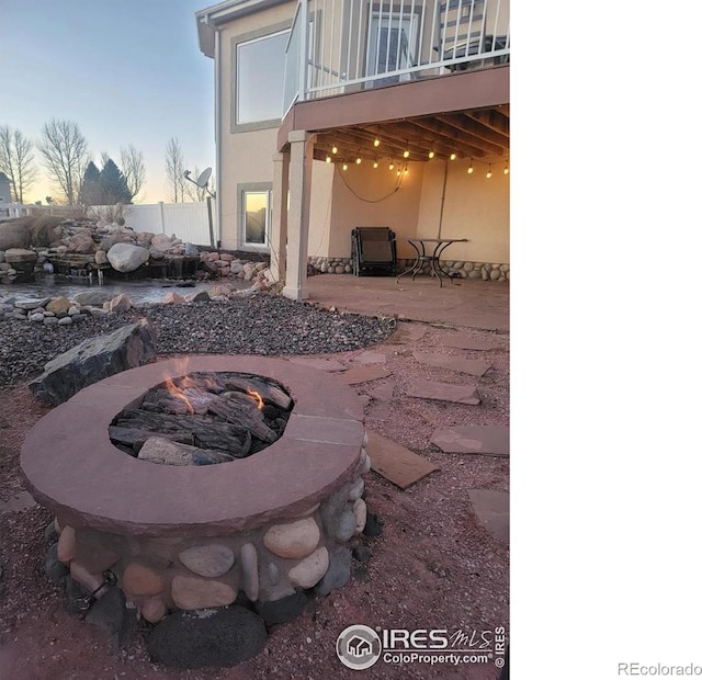 patio terrace at dusk featuring a fire pit