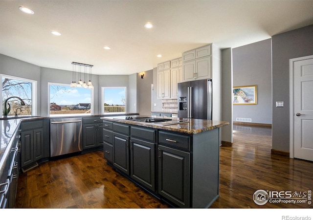 kitchen featuring a wealth of natural light, a center island, sink, and appliances with stainless steel finishes