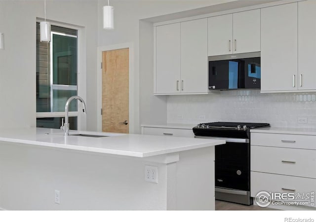 kitchen featuring white cabinets, sink, tasteful backsplash, decorative light fixtures, and stainless steel appliances