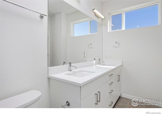 bathroom featuring vanity, tile patterned flooring, and toilet