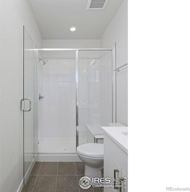 bathroom with tile patterned floors, an enclosed shower, toilet, and vanity