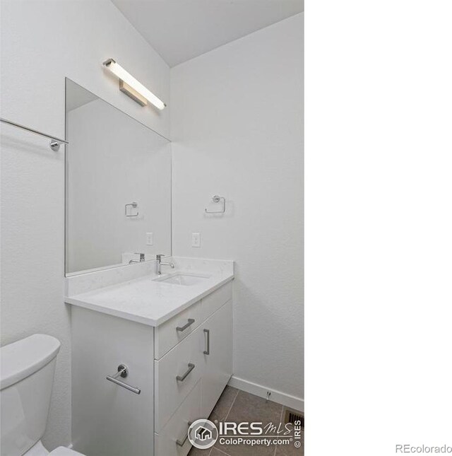 bathroom featuring tile patterned flooring, vanity, and toilet