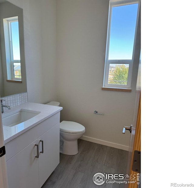 bathroom featuring vanity, toilet, and hardwood / wood-style flooring