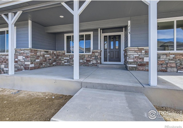 entrance to property with stone siding and covered porch