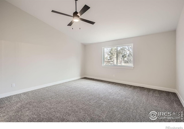 carpeted empty room with a ceiling fan, vaulted ceiling, and baseboards