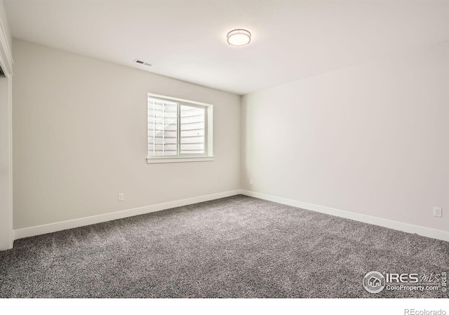 carpeted spare room featuring baseboards and visible vents