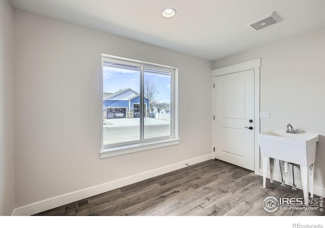 spare room featuring recessed lighting, wood finished floors, visible vents, and baseboards