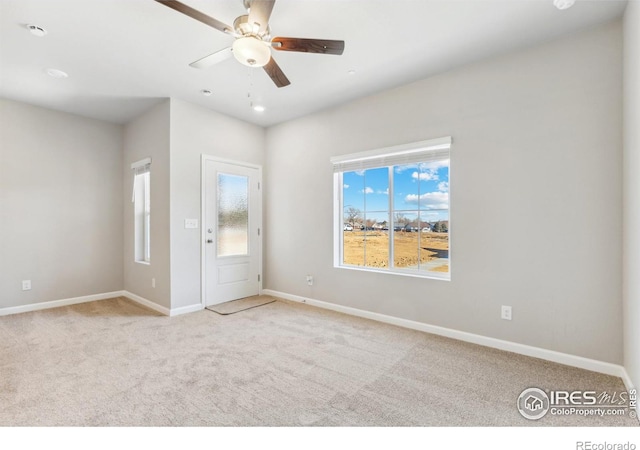 carpeted spare room with ceiling fan