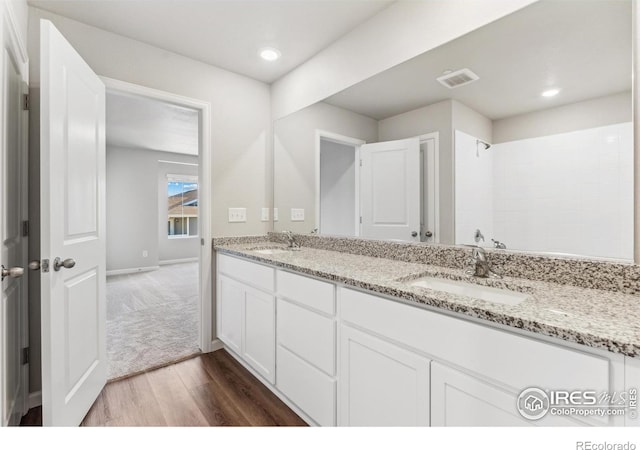 bathroom featuring double vanity and hardwood / wood-style flooring