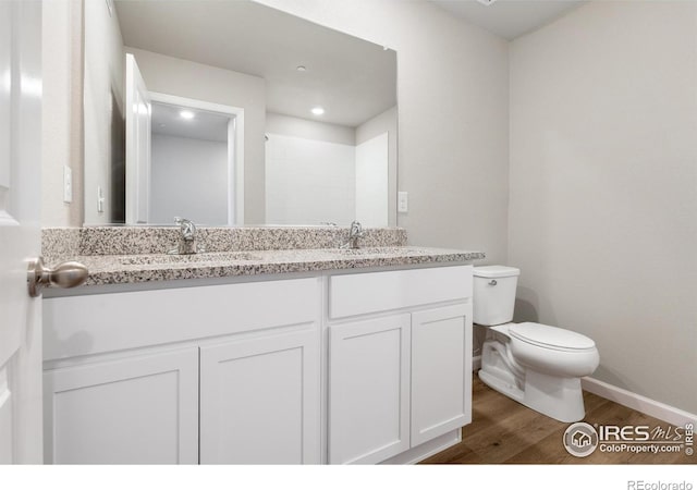 bathroom featuring hardwood / wood-style flooring, toilet, and vanity