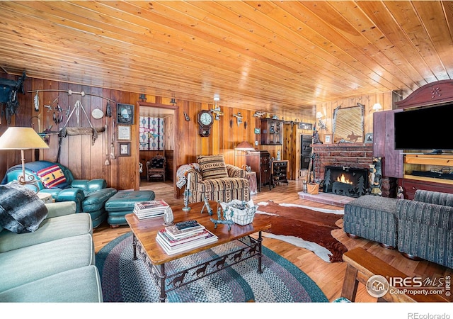 living room with wooden ceiling, hardwood / wood-style flooring, wooden walls, and a brick fireplace